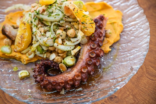 اخطبوط مشوي على الفحم مع الفاصوليا والشمر ونبات الكبر وبرتقال مشوي